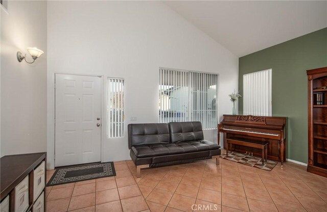 entrance foyer featuring light tile patterned floors and high vaulted ceiling