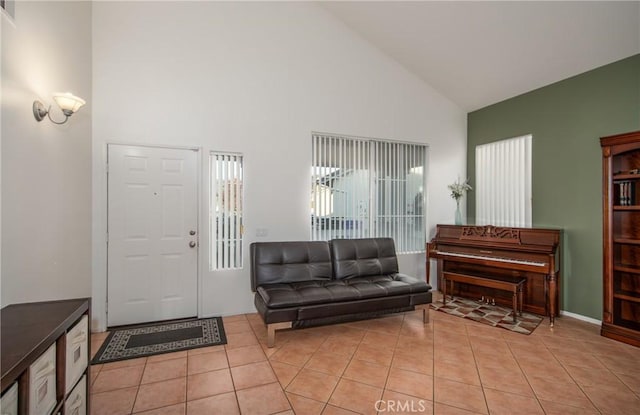 entrance foyer featuring high vaulted ceiling and light tile patterned flooring