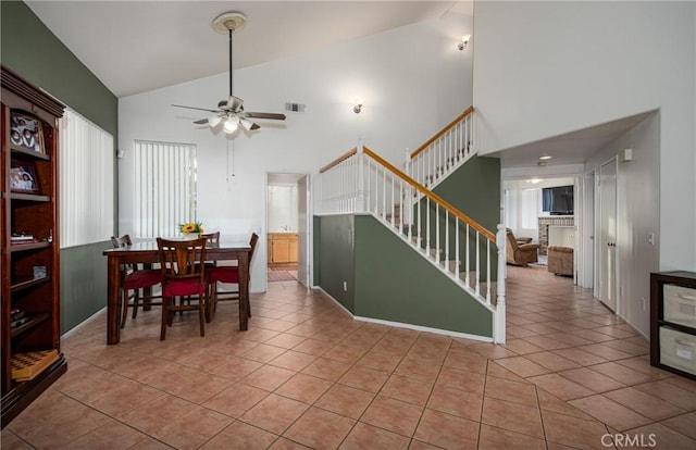 dining room with light tile patterned floors, high vaulted ceiling, and ceiling fan