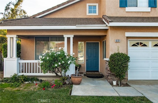 property entrance with covered porch and a garage