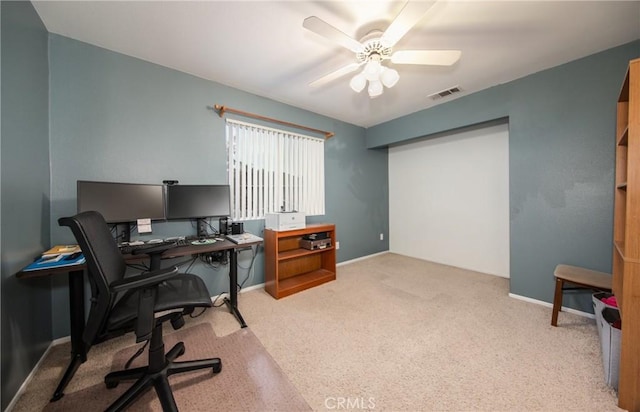 carpeted office space with ceiling fan