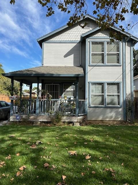 back of house featuring a porch and a yard