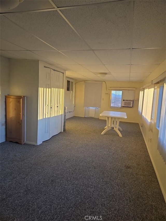 spare room with a paneled ceiling, a wall mounted air conditioner, and carpet floors