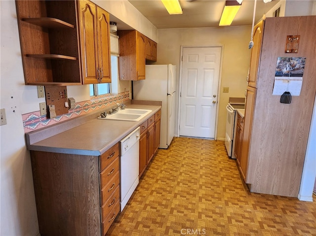 kitchen featuring white appliances, sink, and light parquet flooring