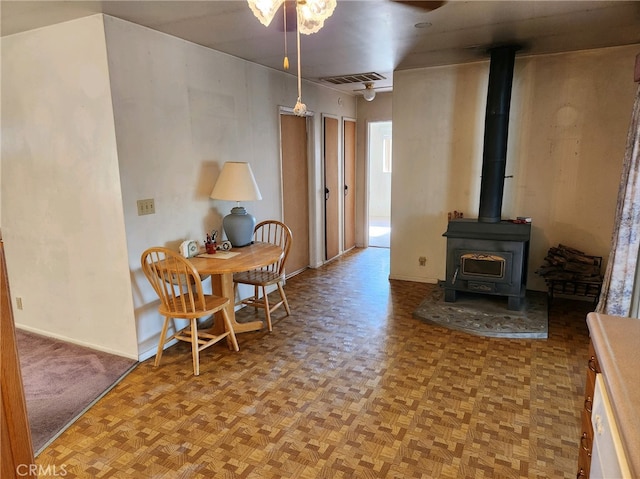 dining room with a wood stove and light parquet floors