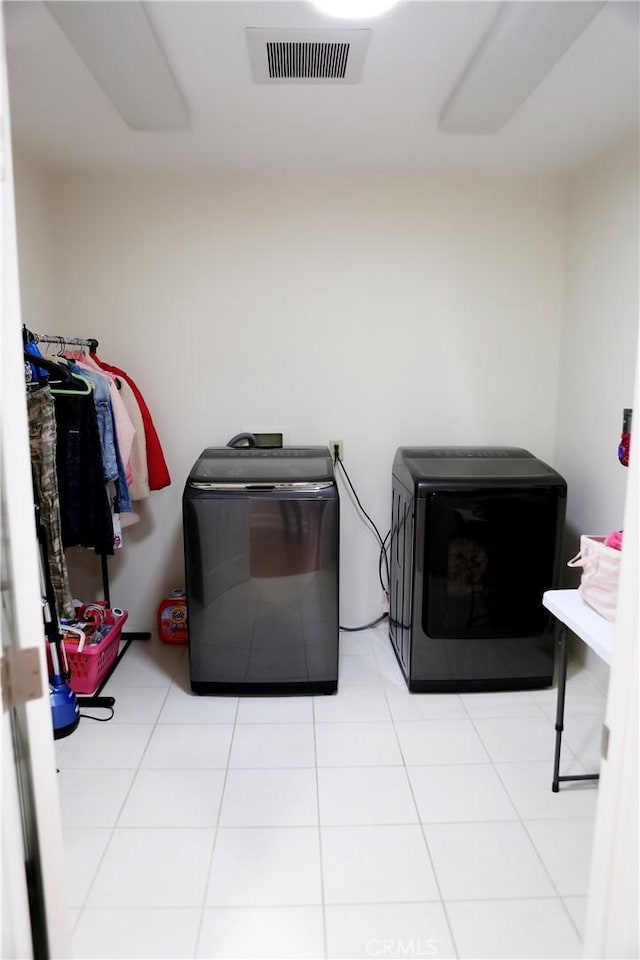 washroom with light tile patterned floors and washing machine and clothes dryer