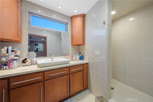 bathroom featuring vanity, tile patterned floors, walk in shower, and tile walls