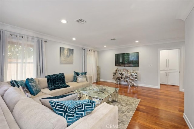 living room featuring light hardwood / wood-style floors and crown molding