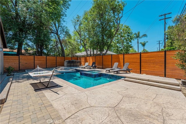 view of swimming pool with an in ground hot tub and a patio