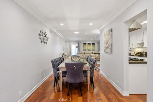 dining area with hardwood / wood-style flooring and ornamental molding