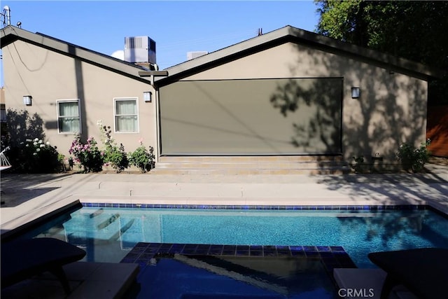 view of swimming pool featuring cooling unit and a patio area