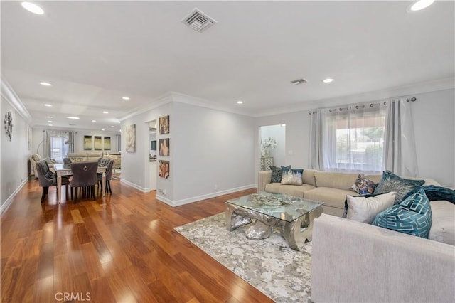 living room featuring wood-type flooring and ornamental molding