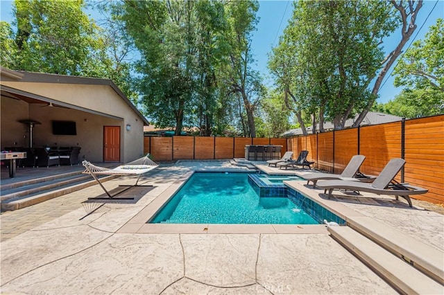 view of swimming pool featuring a patio area and an in ground hot tub