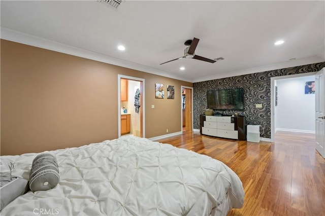 bedroom with hardwood / wood-style flooring, ceiling fan, ornamental molding, and connected bathroom