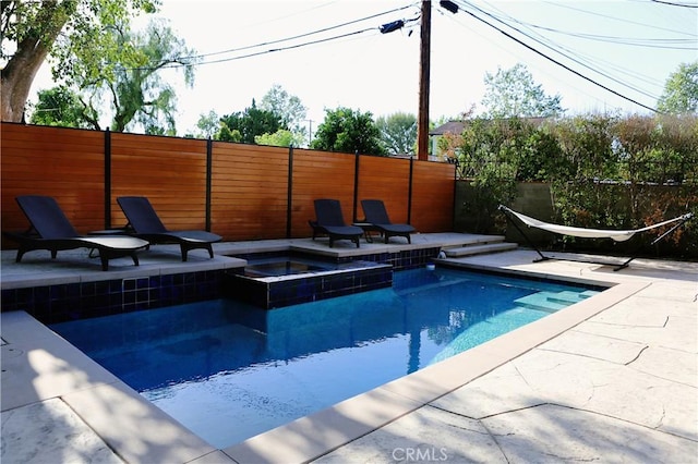 view of swimming pool featuring an in ground hot tub and a patio