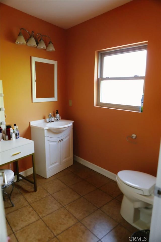 bathroom with toilet, vanity, and tile patterned floors