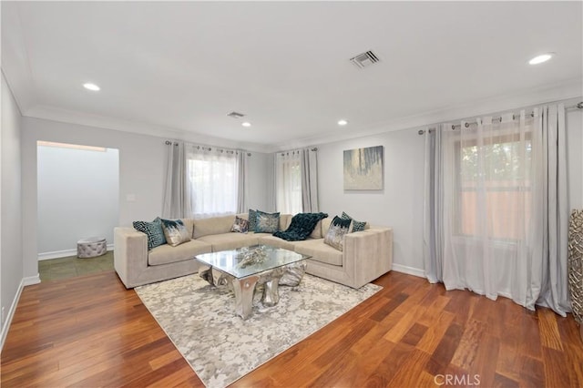 living room featuring wood-type flooring and ornamental molding