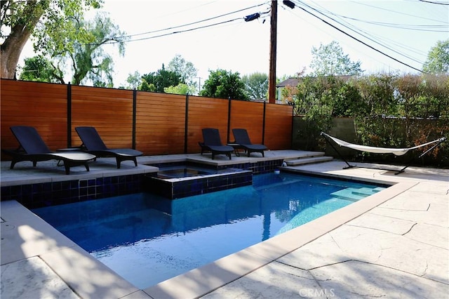 view of swimming pool with a patio area and an in ground hot tub