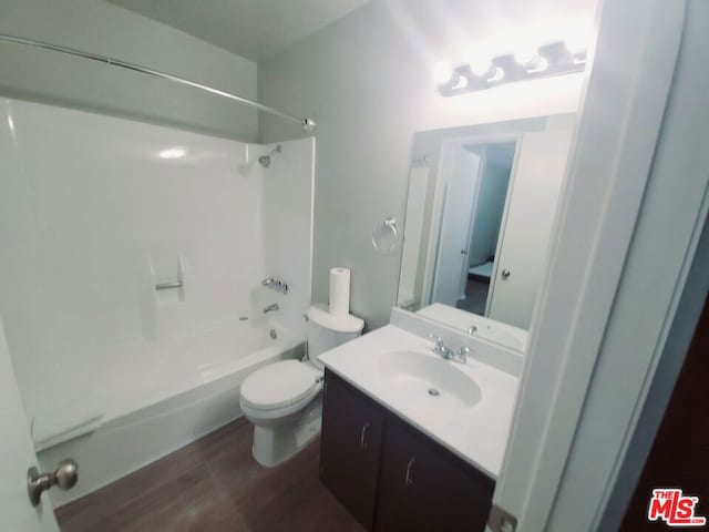 full bathroom with bathing tub / shower combination, hardwood / wood-style floors, vanity, and toilet