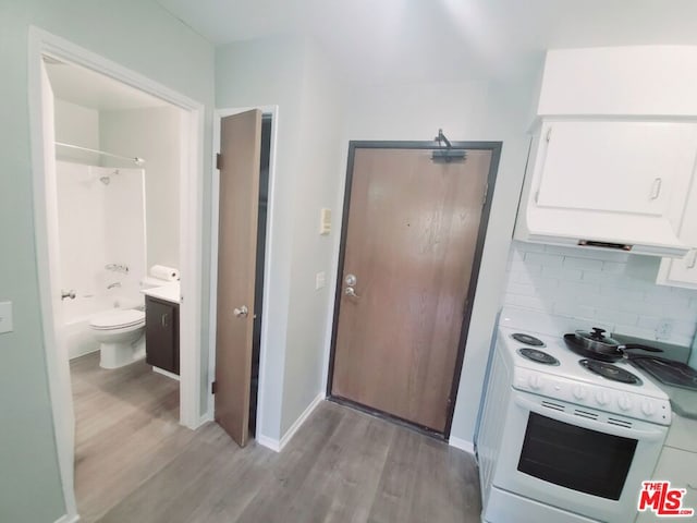 kitchen with white cabinets, white range with electric stovetop, decorative backsplash, and light wood-type flooring