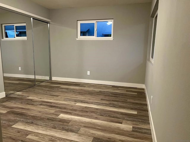 unfurnished bedroom with a closet and dark hardwood / wood-style flooring