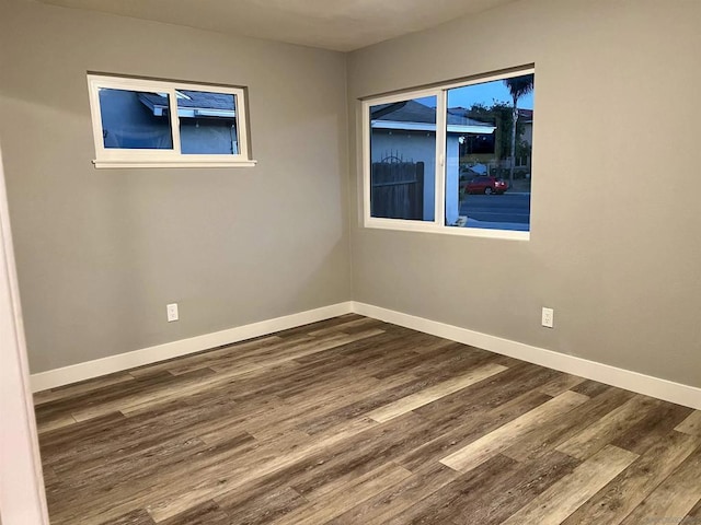 unfurnished room featuring dark wood-type flooring