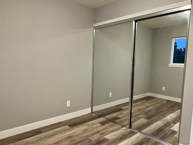 unfurnished bedroom with wood-type flooring and a closet