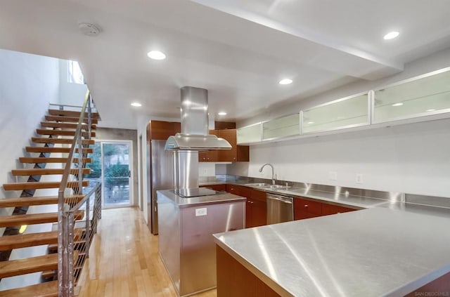 kitchen featuring island exhaust hood, stainless steel counters, sink, dishwasher, and light hardwood / wood-style floors