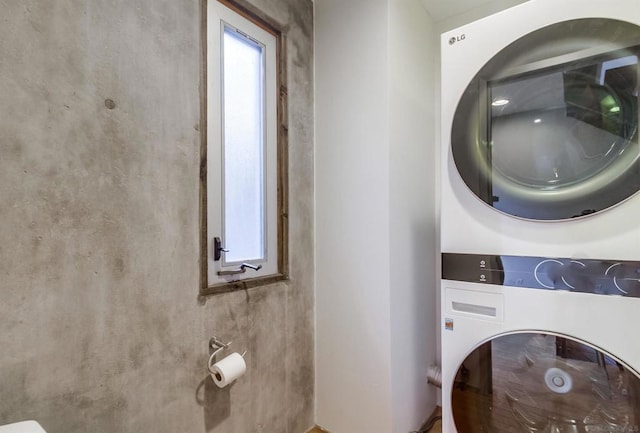 clothes washing area featuring stacked washer / drying machine