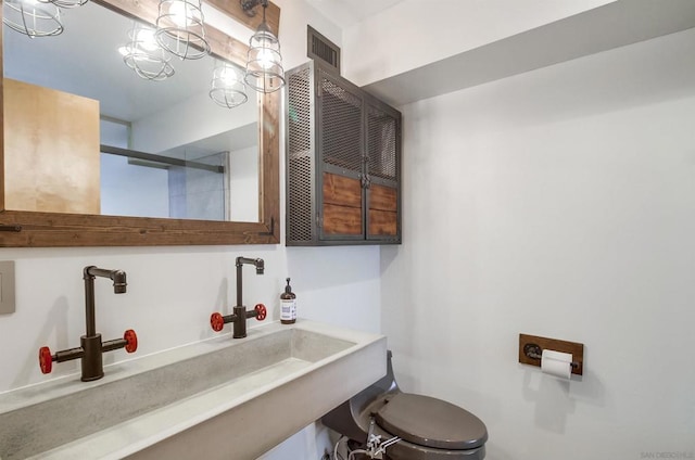 bathroom with sink and an inviting chandelier