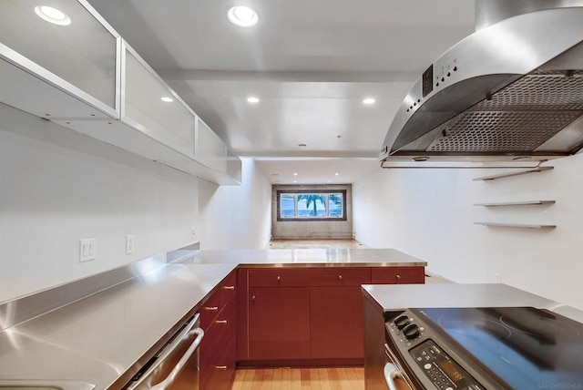 kitchen featuring stainless steel counters, stainless steel appliances, range hood, and washer / dryer