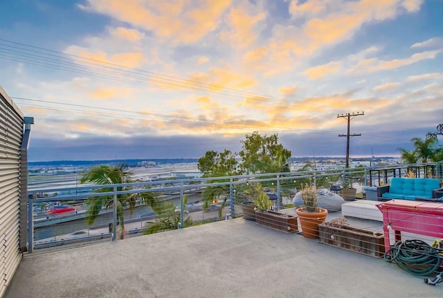 patio terrace at dusk featuring a balcony