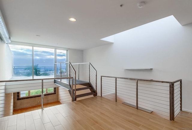 stairs featuring hardwood / wood-style flooring and plenty of natural light