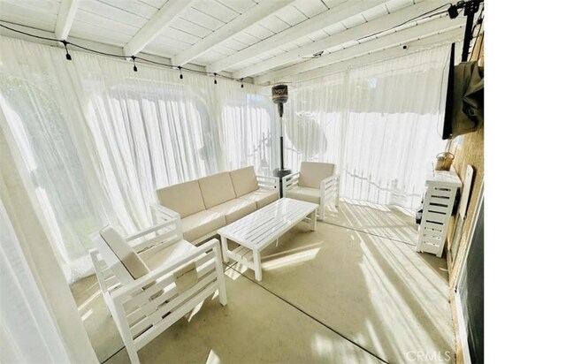 sunroom / solarium with beam ceiling and a healthy amount of sunlight