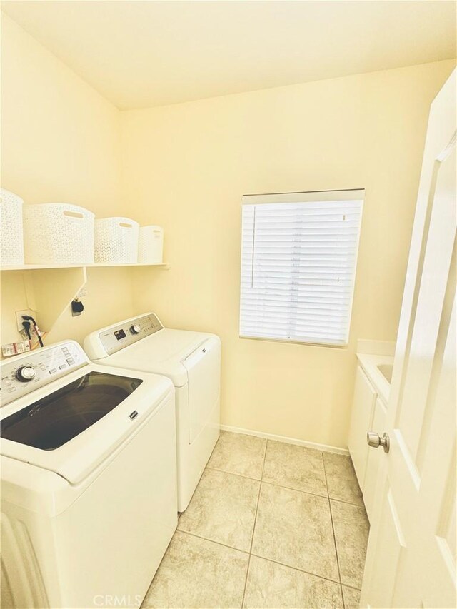 laundry room featuring separate washer and dryer and light tile patterned floors