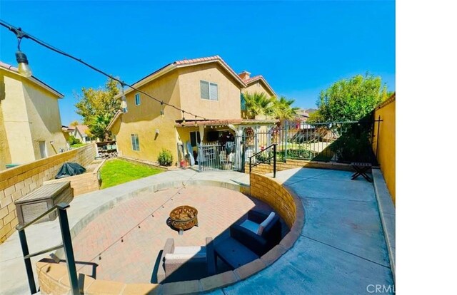 back of house featuring a patio and a fire pit