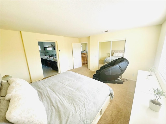 bedroom with light carpet and connected bathroom