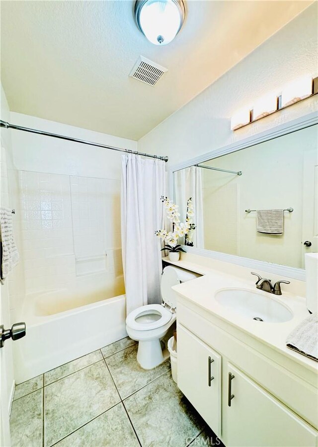 full bathroom featuring tile patterned floors, shower / bath combo with shower curtain, vanity, and toilet