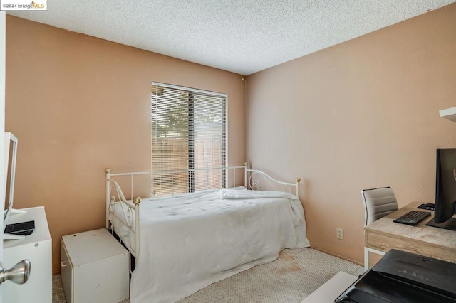 carpeted bedroom featuring a textured ceiling