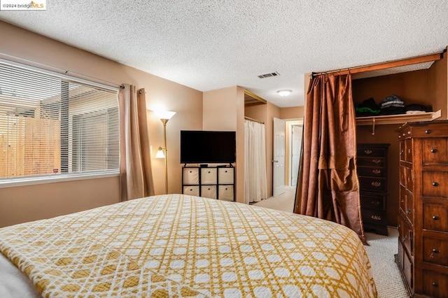 carpeted bedroom with a textured ceiling