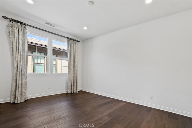 empty room with dark hardwood / wood-style flooring