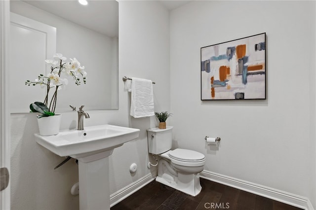 bathroom featuring toilet and wood-type flooring