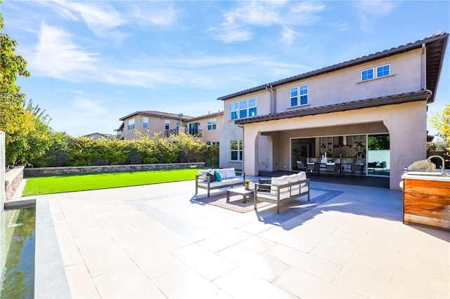 rear view of house with outdoor lounge area and a patio