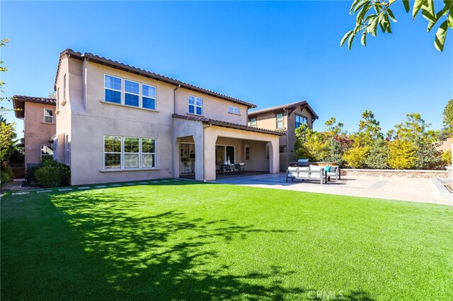 rear view of property featuring a patio area and a yard