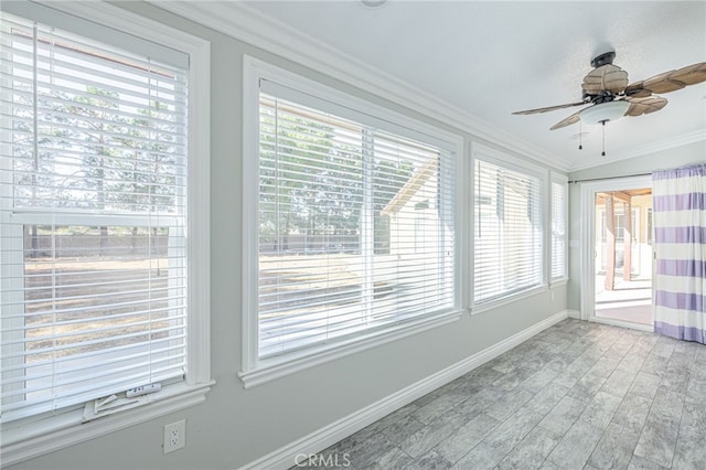 unfurnished sunroom with ceiling fan