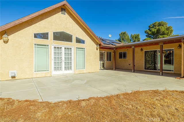 back of house with solar panels and a patio area