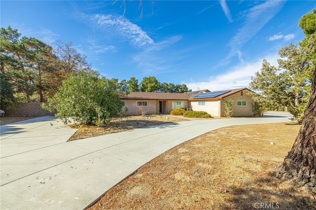 single story home featuring solar panels