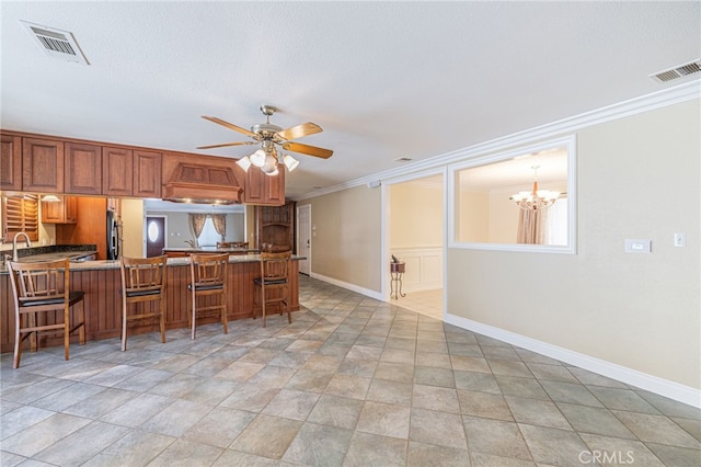 kitchen featuring a kitchen breakfast bar, ornamental molding, kitchen peninsula, ceiling fan with notable chandelier, and custom exhaust hood