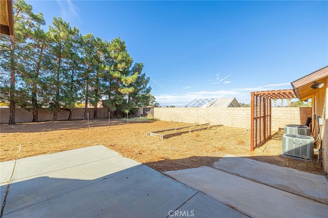 view of yard with central AC unit and a patio