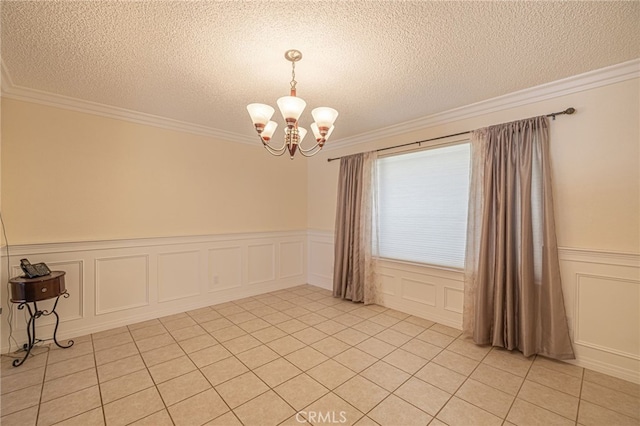 tiled spare room with ornamental molding, a textured ceiling, and an inviting chandelier